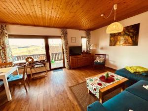 a living room with a blue couch and a table at 2 - Gemütlicher Bungalow am Fuße der Wasserkuppe in Dipperz