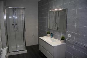 a bathroom with a shower and a sink and a mirror at Katana Apartments in Catania