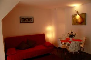 uma sala de estar com um sofá vermelho e uma mesa em Katana Apartments em Catânia