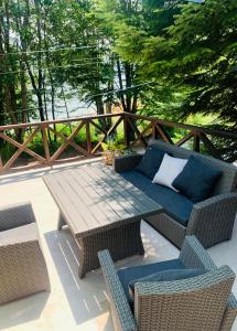 um pátio com uma mesa de madeira e cadeiras de vime em Laki's House em Mavrovo
