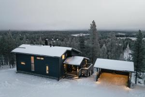 una cabaña en la nieve en el bosque en Villa Välke - Relax In Style, en Pyhätunturi