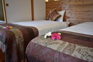 本部町にあるPool and Sauna villa Kanasa 新規オープンセール中2のホテルルーム 花の飾られたベッド2台付 +45枚の写真