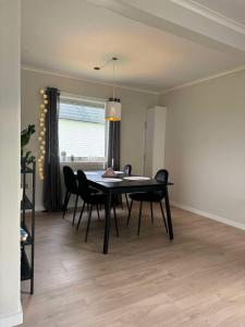a dining room with a black table and chairs at Arctic Haven Apartment in Berlevåg +1 photo