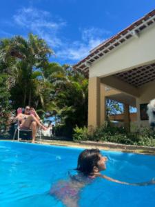 Eine Frau in einem Schwimmbad neben einer Frau. in der Unterkunft O melhor lugar pra família, em Tamandaré in Tamandaré
