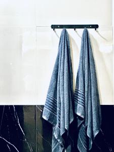 Dos toallas colgadas en un estante en un baño. en niti house with 2 bed room 1 bath, en Roi Et