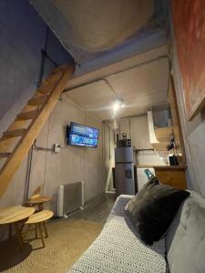 ein Wohnzimmer mit Sofa und Küche in einem Minihaus in der Unterkunft AKA Tiny House in Matanzas