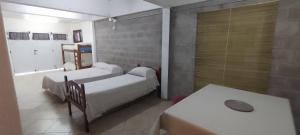 a hospital room with three beds and a table at Dulce Sol Hospedaje in Gualeguaychú