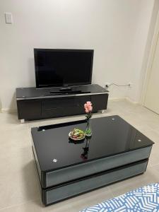 - un salon avec une télévision et une table basse en verre dans l'établissement Private brand new home in Hornsby, à Hornsby Heights
