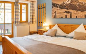 a bedroom with a large bed with white sheets at Haus Hirschpoint Ferienwohnungen in Ramsau