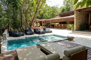 a pool with chaise lounges and chairs next to a house at SITIO VILLA DA MATA in São Miguel dos Milagres