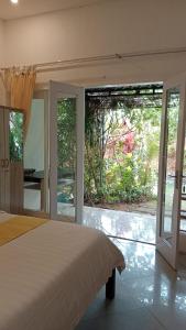 a bedroom with a bed and sliding glass doors at Summer Homestay Bali in Nusa Dua