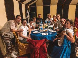 a group of people sitting around a table in a tent at Desert Camp Merzouga Nights in Merzouga