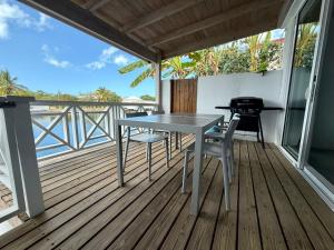 Jolly HarbourLuxury Waterfront Villa 431F Starlink Wifi的甲板上的桌椅,配有烧烤架