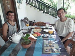 dos hombres sentados en una mesa con comida. en Liyara Home Stay, en Sigiriya 74 fotos más