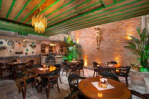 a restaurant with wooden tables and chairs and a brick wall at Cappadocia Chiaro in Uçhisar