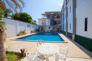 a patio with a table and chairs next to a swimming pool at Hotel Galería del Ángel in Santa Cruz Huatulco