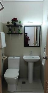 a bathroom with a toilet and a sink and a mirror at Primavera Cozy studio Condominium, Cagayan de Oro City, Philippines in Cagayan de Oro