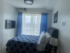 a bedroom with a blue bed and a window at Primavera Cozy studio Condominium, Cagayan de Oro City, Philippines in Cagayan de Oro +10 photos