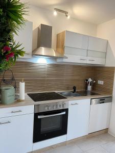 LeiningenにあるFerienwohnung im Hunsrück Neubauの白いキャビネットとコンロ付きオーブンを備えたキッチン