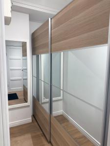 a closet with glass doors and a mirror at Charming City Studio, 10 Min Walk to Train Station in Stockholm