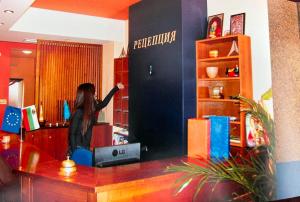 a woman standing on a counter in a room at Hotel MERIDA in Blagoevgrad