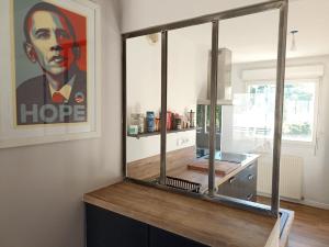 a kitchen with a painting of a man on the wall at Cozy T3 appartement 70m2- Plescop in Plescop