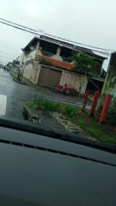 a house with a motorcycle parked in front of a street at Regis pensão in Praia Grande