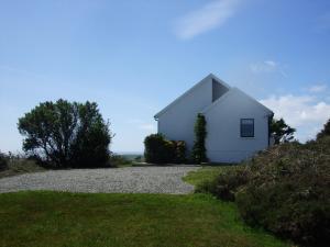 a white house on the side of a gravel road at Ardeevan Schull in Schull