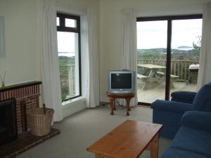 a living room with a blue couch and a tv at Ardeevan Schull in Schull