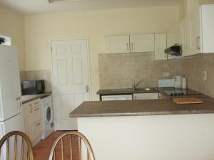 a kitchen with white cabinets and a counter top at Ardeevan Schull in Schull +5 photos