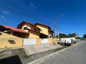 a house with a car parked next to a street at Casa Amarela in Penha