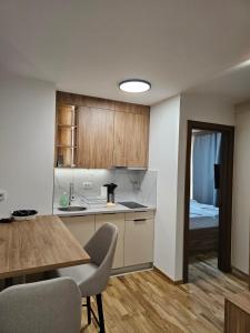 a kitchen with a table and a kitchen with a bed at Apartmani Corner in Jahorina +9 photos