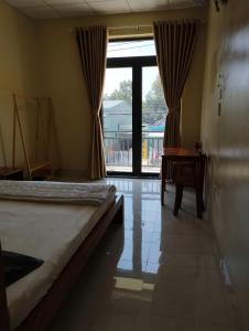 ハティエンにあるHoa Dũng homestayのベッドと大きな窓のある寝室 +6枚の写真