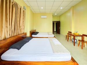 ハティエンにあるHoa Dũng homestayの2ベッド テーブル2台付きの部屋