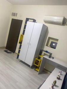 an empty room with a white cabinet and a shelf at Karada Abu Nawas private room in Baghdad