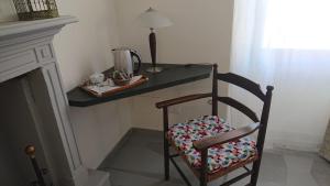 a chair sitting in front of a counter with a table at Piccolo Bacco dei Quaroni in San Damiano al Colle +13 photos