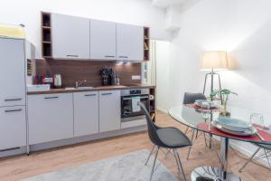 a kitchen with white cabinets and a table with chairs at LiT LiVING - Luxus - Box SprIng - WH Old Town - Parking in Weinheim +14 photos