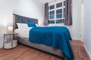 a bedroom with a bed with a blue blanket on it at LiT LiVING - Luxus - Box SprIng - WH Old Town - Parking in Weinheim