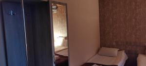 a bedroom with a mirror and a bed in a room at Hotel Svanseti in Mestia