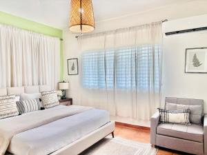 a bedroom with two beds and a chair at Dream vacation at Hacienda Carabali in Luquillo +59 photos