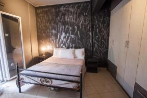 a bedroom with a bed with a black wall at Vana's Appartment Trikala DownTown in Tríkala
