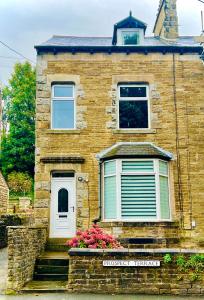 a brick house with a window and flowers in front at Prospect House in Settle
