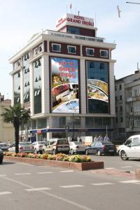 Un gran edificio con coches aparcados en un estacionamiento. en Hotel Grand Eregli, en Ereğli