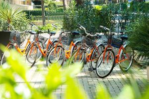 een groep fietsen geparkeerd naast elkaar bij Hotel Milano in Eraclea Mare