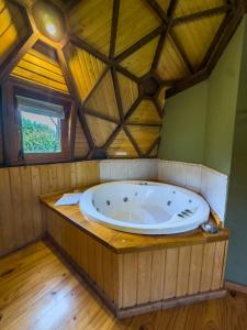 a large tub in a room with a wooden ceiling at Domos Puelo in Lago Puelo +43 photos