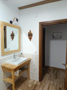 ein Badezimmer mit Waschbecken und Spiegel in der Unterkunft Casa Rural el Pajar Piscina para 3 apartamentos in Argamasilla de Alba