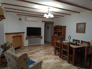 ein Wohnzimmer mit Tisch und Fernseher in der Unterkunft Casa Rural el Pajar Piscina para 3 apartamentos in Argamasilla de Alba