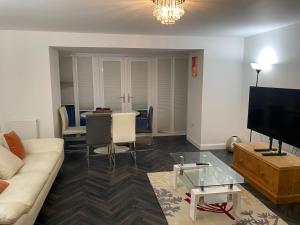 a living room with a couch and a table at 4 Bed Station Garden House in Basingstoke