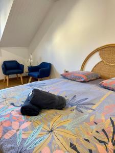 a bed with a towel on it with two blue chairs at BLUE MOON in Saint-Nazaire