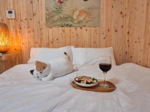 a cat laying on a bed with a plate of food and a wine glass at #편백나무 #아지트 #Lucky Oasis #정자재래시장 #스타필드 #수원종합운동장 #커플추천 #낮시간이용가능 #평일할인 in Suwon +9 photos